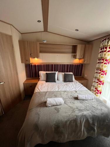 a bedroom with a large bed with towels on it at Peaceful Whitley Bay Getaway with Shared Indoor Pool in Whitley Bay
