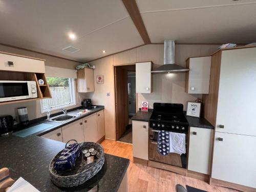 a kitchen with white cabinets and a stove top oven at Peaceful Whitley Bay Getaway with Shared Indoor Pool in Whitley Bay