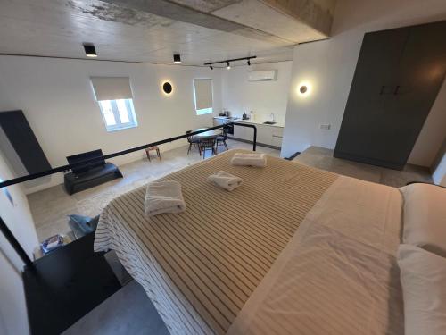 a bedroom with a large bed with two towels on it at Prime Fully Equipped Studio 4 Ideal Base to Explore Malta in Il-Furjana