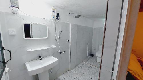 a white bathroom with a sink and a mirror at Econest arugambay in Arugam Bay