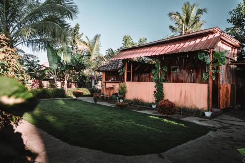 een huis met een groen gazon ervoor bij Kurni's Cabin in Sapit
