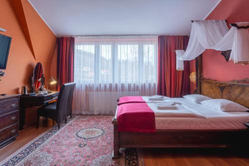 a bedroom with a bed and a desk and a window at Centrum Green Hill Business & SPA in Wisła