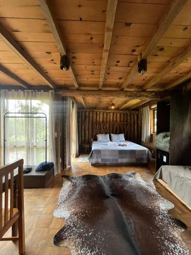 a large bedroom with a bed and a wooden ceiling at Divina Reserva- Cabana Maçanilha in Bom Retiro
