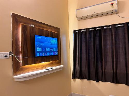 ein Badezimmer mit einem Fernseher in einem Fenster mit Vorhang in der Unterkunft Roomssolution ! Best Hotel In Patna in Gulzārbāgh