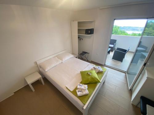 a small bedroom with a bed and a balcony at Apartments Matteo in Omišalj