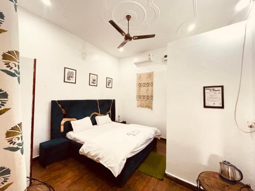 een slaapkamer met een bed en een plafondventilator bij Stayble Homestay in Dehradun