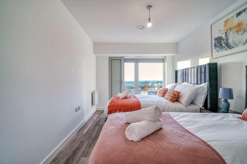 a bedroom with two beds and a large window at 2-BR Flat - City & Town Centre View -1 Minute to Train & Tram Station - Sleeps 5 in Manchester