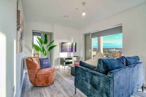 a living room with two blue chairs and a window at 2-BR Flat - City & Town Centre View -1 Minute to Train & Tram Station - Sleeps 5 in Manchester