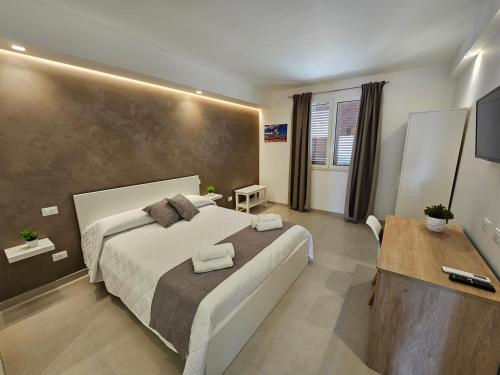 een slaapkamer met een groot bed met handdoeken erop bij Aura B&B in Pachino