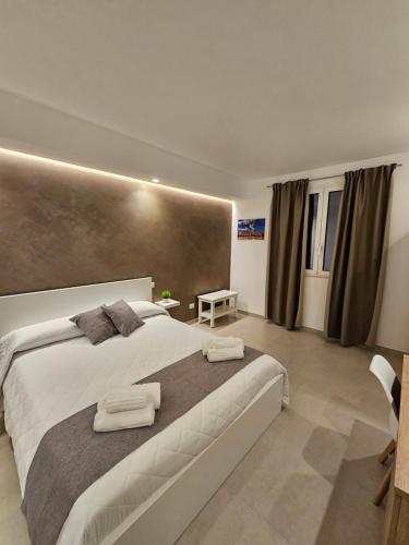 een slaapkamer met een groot bed met twee handdoeken erop bij Aura B&B in Pachino