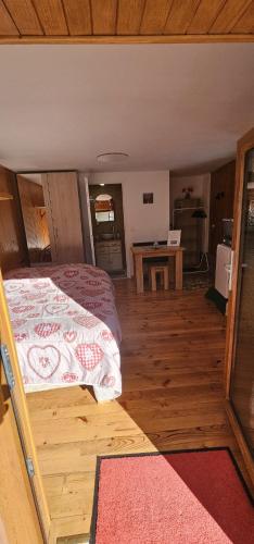 une chambre avec un lit et un parquet dans l'établissement Le coquelicot, à Val Cenis