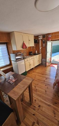 une cuisine avec un sol en bois et une table en bois dans l'établissement Le coquelicot, à Val Cenis