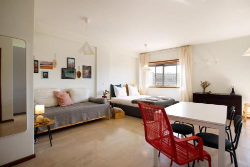 a living room with a couch and a table at Casa Guilhermina, Sunny Studio with Balcony in Porto