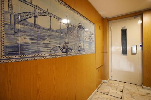 a painting of a bridge on a wall next to a door at Casa Guilhermina, Sunny Studio with Balcony in Porto