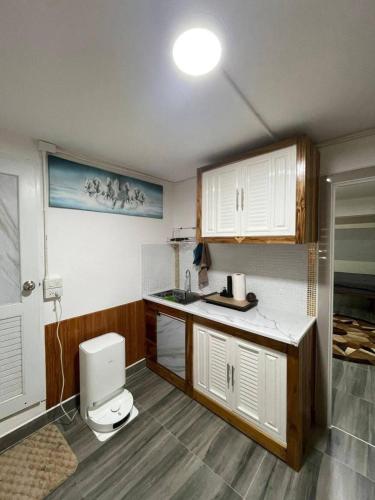 a small kitchen with a sink and a toilet at Lee Red House Homestay in Ban Ao Yai