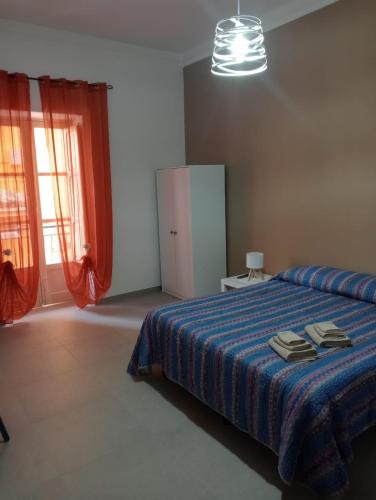 a bedroom with a bed with a blue comforter at Penelope in Agrigento