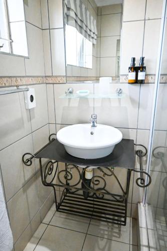 a bathroom with a sink on a glass table at Matts Rest Bnb & Self-catering in Pietermaritzburg