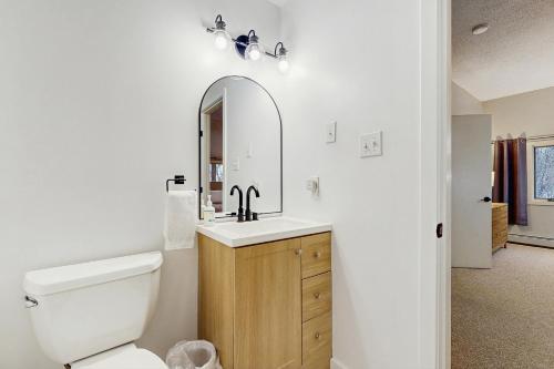 un bagno con un water, un lavandino e uno specchio di Kingswood Mountainside Retreat a White River Junction