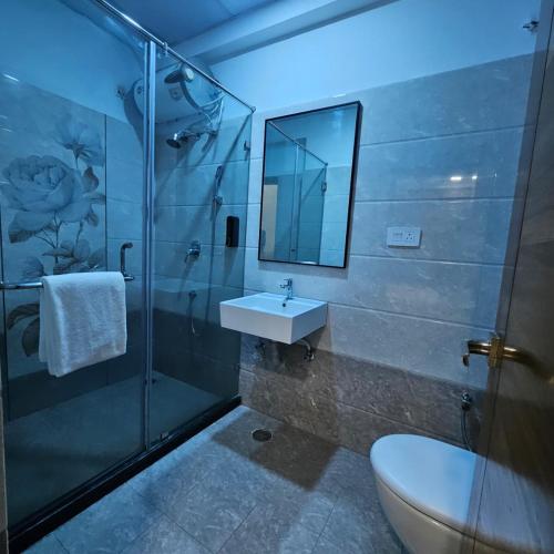 a bathroom with a toilet and a sink and a shower at Stae Residency Hitec City in Hyderabad