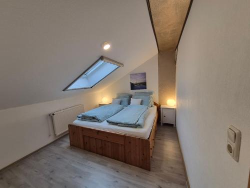 a bedroom with a large bed with a skylight at Ferienwohnung Thomée - Ruhig gelegen, ideal für Monteure und Erholungssuchende in Looft