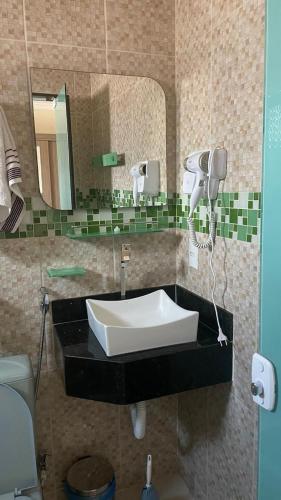 a bathroom with a sink and a mirror at Casa temporada em Perocão in Guarapari