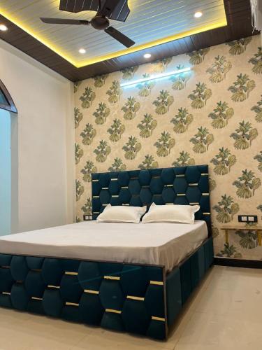 a bedroom with a large bed with a blue headboard at Green Valley Residency in Lucknow