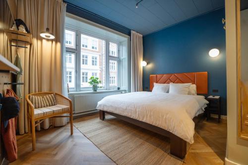 a bedroom with a large bed and a window at Hotel Mayfair in Copenhagen