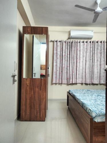 a bedroom with a wooden door and a mirror at Sunset stay in Daman