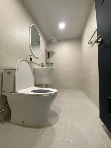 a white bathroom with a toilet and a mirror at 더스테이365 디럭스 in Seoul