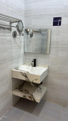a bathroom with a sink and a mirror at فندق ثرا الرواد in Abu Arish