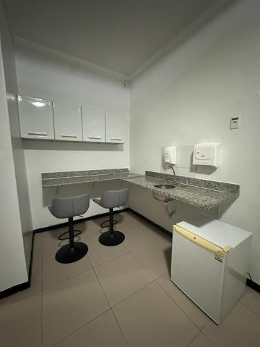 a bathroom with two stools and a sink in a room at Hotel Araras in Manaus
