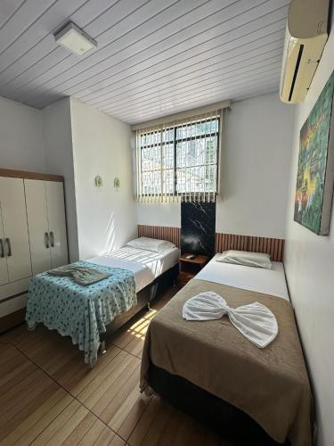 a room with two beds and a window in it at Hotel Araras in Manaus