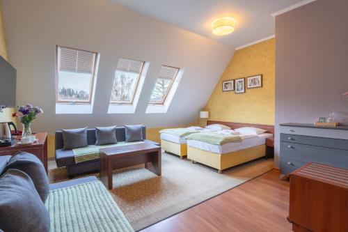 un soggiorno con due letti e un divano di Apartamenty przy Głównym Deptaku a Wisła