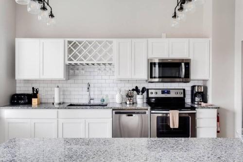 a kitchen with white cabinets and a stove top oven at Historic Elegance Modern Amenities Gym in Louisville