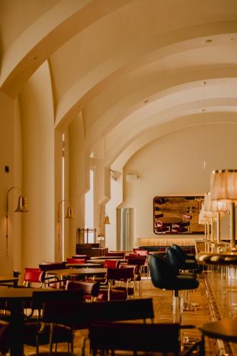 een lege ruimte met tafels en stoelen en een piano bij Wilde Vienna Fleischmarkt in Wenen