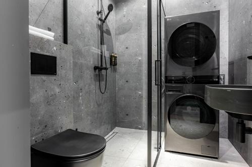 een badkamer met een wasmachine en een wastafel bij Memel Town Apartments in Klaipėda