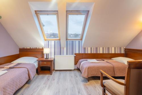 a room with two beds and two windows at Apartamenty przy Głównym Deptaku in Wisła
