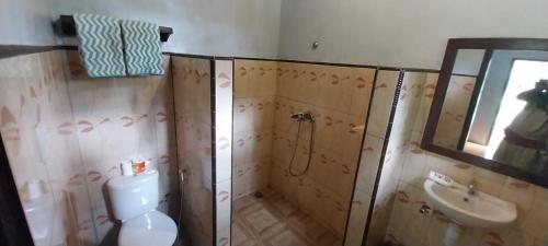 a bathroom with a shower and a toilet and a sink at Hadi Homestay Garden View in Jambu