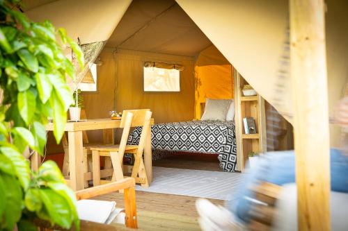 a room with a table and a bed in a tent at Odyssey Eco Farm Glamping in Galatas