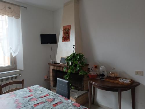 een woonkamer met een tafel, een bureau en een televisie bij Casa da Lucy-Monsummano Terme in Monsummano