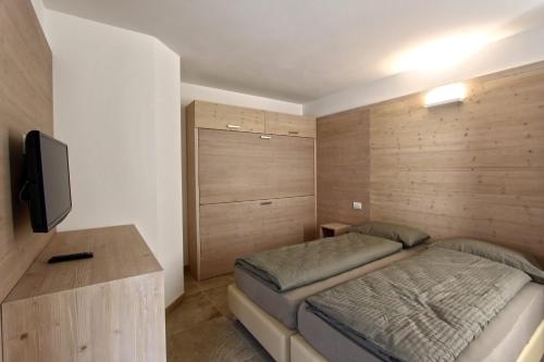 una camera da letto con un letto e una TV a schermo piatto di Appartamento Alpen Molveno a Molveno