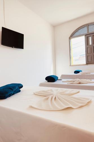 two beds in a room with a tv on the wall at Hotel Dairy Walley in Itapetinga