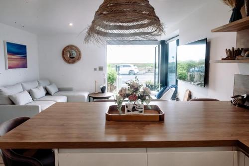 a living room with a table with flowers on it at Coast Beachfront GF 6 guests dog friendly apartment in Southbourne
