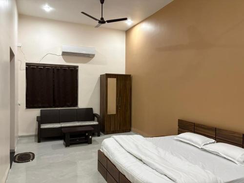 a bedroom with a bed and a couch at ENERGY Inn in Kotri Kalān