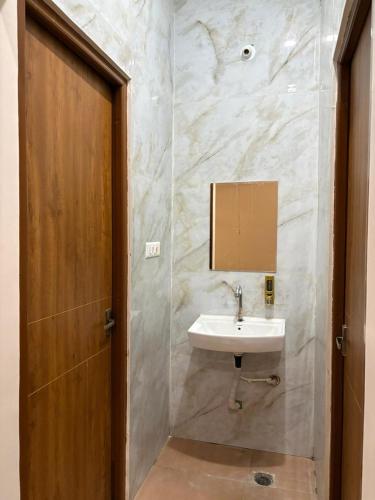 a bathroom with a sink and a wooden door at ENERGY Inn in Kotri Kalān