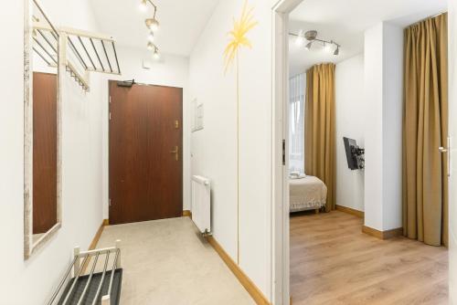 a hallway with a door and a room with a bed at Apartamenty Oaza Superior Zakopane in Zakopane