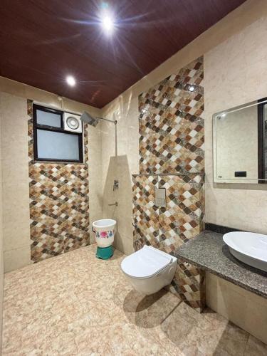 a bathroom with a toilet and a sink at Goel Villa and Hotel in Allāhābād Junction