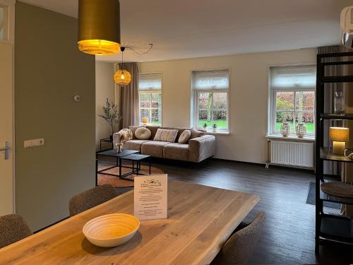 a living room with a table and a couch at Summio Villaparc Schoonhovenseland in Hollandscheveld
