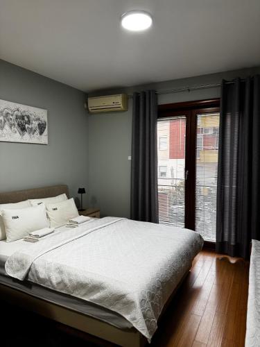 a bedroom with a large bed and a window at IWA CENTAR Apartments & Wellness in Vrnjačka Banja