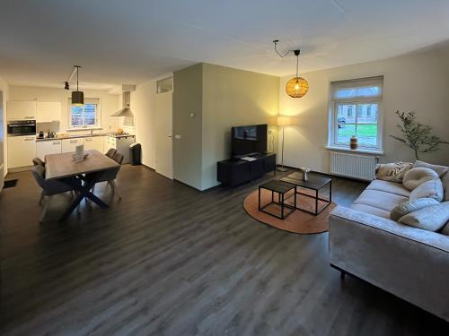 a living room with a couch and a table at Summio Villaparc Schoonhovenseland in Hollandscheveld